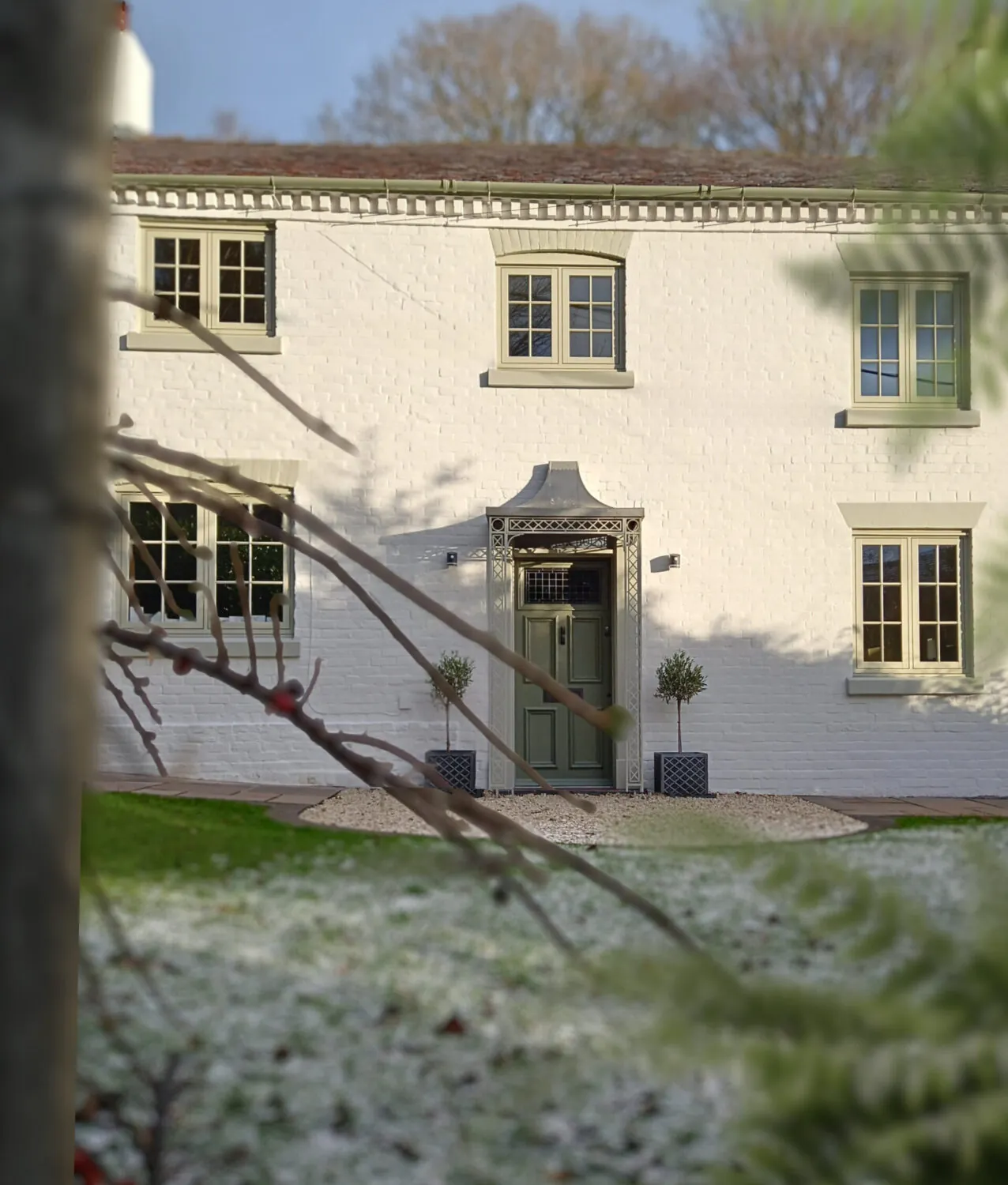 A newly painted white home in snowy conditions