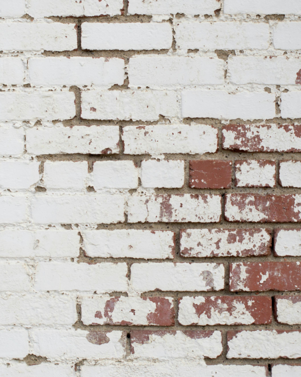 Peeling paint on brick wall
