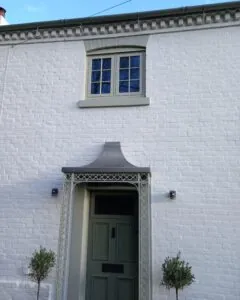 The front of a house painted with Heritage White masonry paint